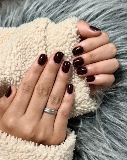 Unhas esmaltadas em vinho escuro, trabalho do Studio Gleyce Antunes